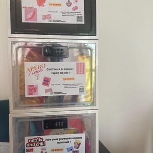 Peut inclure: Trois boîtes de rangement blanches empilées, chacune avec un cadenas à combinaison. La boîte supérieure porte l'inscription "Hot". La boîte du milieu porte l'inscription "Apero Time". La boîte inférieure porte l'inscription "Netflix and Chill".