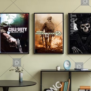 Puede incluir: Tres carteles enmarcados con ilustraciones del videojuego Call of Duty. Los carteles muestran escenas de acción con texto, incluyendo "Call of Duty Black Ops" y "Call of Duty Modern Warfare 2". El tercer cartel presenta un soldado con rostro de calavera.