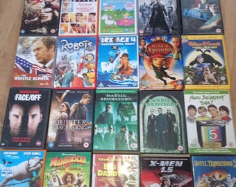 Op de afbeelding: Een verzameling dvd's met diverse filmtitels. De covers tonen een reeks genres, waaronder actie, komedie en animatie. Titels zijn onder meer "Face/Off", "The Matrix", "Madagascar" en "X-Men 1.5". De dvd's zijn gerangschikt op een houten oppervlak.