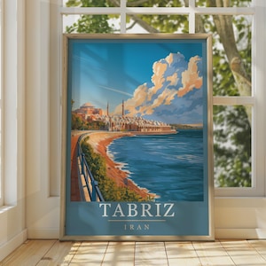 May include: A framed travel poster featuring a stylized illustration of a coastal cityscape with a large domed building and minarets under a blue sky with orange-tinted clouds. The text TABRIZ IRAN is printed in white at the bottom of the print.