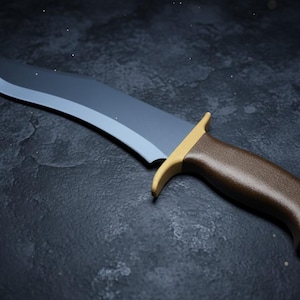 Könnte beinhalten: Ein feststehendes Messer mit einer geschwungenen, mattgrauen Stahlklinge und einem strukturierten braunen Griff. Das Messer verfügt über ein goldfarbenes Metallparierelement zwischen Griff und Klinge, das einen deutlichen Kontrast bildet.