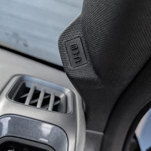 May include: A black textured plastic vehicle A-pillar trim piece featuring a small rectangular emblem with the embossed text SRS AIRBAG. The component is positioned adjacent to a dark grey plastic air vent assembly within a car interior.