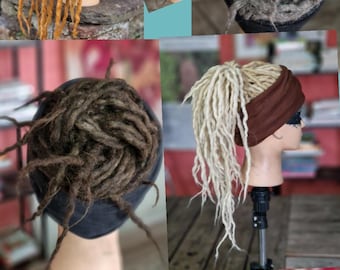 Könnte beinhalten: Eine Sammlung von Dreadlock-Haarverlängerungen in verschiedenen Farben, darunter blond, braun, grau und orange. Die Verlängerungen werden auf Mannequin-Köpfen mit schwarzen Stirnbändern präsentiert.