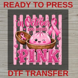 May include: A graphic design featuring a pink cartoon dumpling in a wooden bowl with the text In October we wear PINK. The background has vertical pink stripes and small pink hearts. A pink awareness ribbon is positioned on the right side.