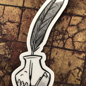 May include: A black and white illustration of a quill pen in an inkwell. The inkwell is filled with black ink and has a mountain landscape design. The quill pen is a gray color and has a white tip.