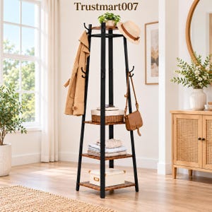 May include: A tall, black metal coat rack with four tiers of wooden shelves. The unit features multiple hooks for hanging items, including a tan coat, a straw hat, and a brown leather bag. A white box sits on the bottom shelf. Text reads Trustmart007.
