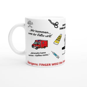 Könnte beinhalten: Weißer Keramikbecher mit schwarzen und roten Grafiken und Text. Der Becher zeigt einen Krankenwagen, eine Schere und eine Spritze. Der Text lautet "Wir kommen... wenn der Kaffee wirkt" und "Adrenalin kann warten - Kaffee nicht."