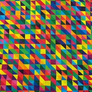 Puede incluir: Una tela con un patrón geométrico repetitivo de pequeños triángulos en una vibrante gama de colores que incluye amarillo, rojo, azul, verde, naranja y morado. El diseño crea un efecto de mosaico denso y multicolor en toda la superficie.