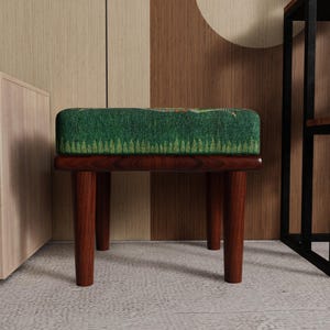 May include: A small, wooden stool with a rectangular, green patterned cushion. The legs are dark brown and angled. The cushion has a forest-like design. The stool is a decorative furniture piece.