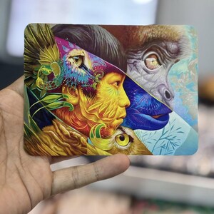 Puede incluir: Una impresi&oacute;n art&iacute;stica rectangular que presenta una ilustraci&oacute;n vibrante y multicapa. La composici&oacute;n muestra un perfil humano mezclado con una cara de primate y un ojo de b&uacute;ho, en tonos saturados de amarillo, azul, morado y verde.