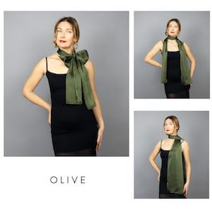 May include: Olive green satin scarf styled in multiple ways. The scarf is draped around the neck and tied in a large bow. The scarf is paired with a black dress. The word "OLIVE" is printed in white.