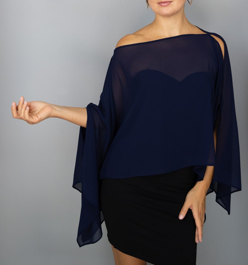 K&ouml;nnte beinhalten: Ein marineblaues Chiffon-Oberteil mit Off-Shoulder-Design und flie&szlig;enden &Auml;rmeln. Das Oberteil wird mit einem schwarzen Kleid kombiniert. Der transparente Stoff f&auml;llt elegant und sorgt f&uuml;r einen raffinierten Look. Das Outfit ist f&uuml;r formelle Anl&auml;sse geeignet.