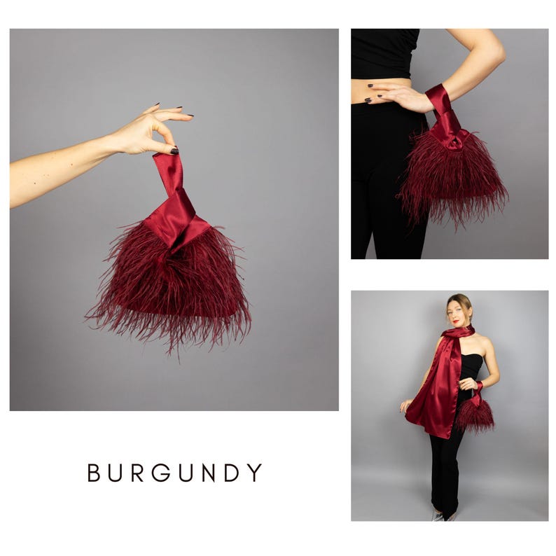 May include: Burgundy satin clutch with feather trim. The clutch is held by a hand in the image. The word "BURGUNDY" is displayed in the image. The clutch is a deep red colour.
