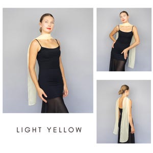 May include: A light yellow scarf draped over a black dress. The scarf is rectangular and appears to be made of a lightweight fabric. The text "LIGHT YELLOW" is at the bottom of the image.
