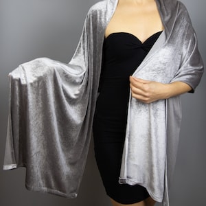 May include: A silver velvet shawl with a soft, flowing drape. The shawl is shown draped over a person's shoulders.