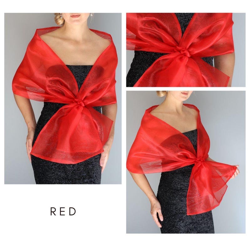May include: A red sheer shawl with a bow tied in the front. The shawl is made of a lightweight fabric and is perfect for adding a touch of elegance to any outfit.