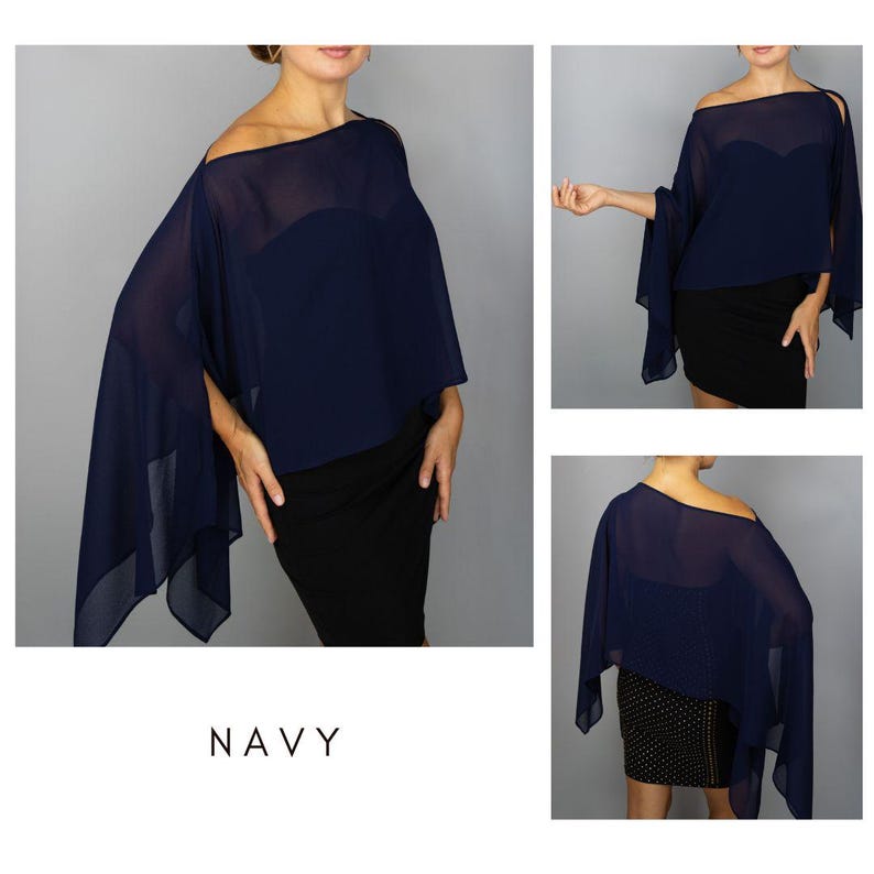 K&ouml;nnte beinhalten: Marineblaues schulterfreies Cape-Top. Der transparente Stoff drapiert &uuml;ber Schultern und Armen und erzeugt eine flie&szlig;ende Silhouette. Das Wort "NAVY" ist unten im Bild in Wei&szlig; gedruckt. Das Top wird mit einem schwarzen Kleid kombiniert.