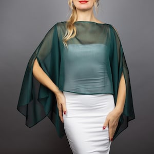 Può includere: Un scialle verde trasparente con scollo a barca e lati aperti. Lo scialle è realizzato in un tessuto leggero ed è perfetto per aggiungere un tocco di eleganza a qualsiasi outfit.