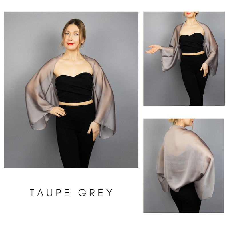 Pode incluir: Xale cinza taupe transparente com mangas largas. O xale &eacute; usado sobre um top e cal&ccedil;as pretas. O texto "TAUPE GREY" &eacute; exibido na parte inferior da imagem. O xale &eacute; feito de um tecido leve e fluido.