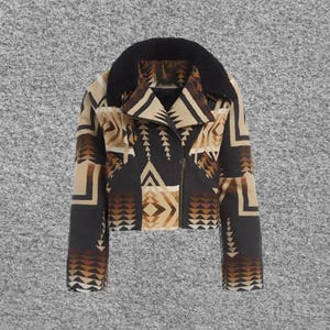 May include: A cropped jacket featuring a black, tan, and brown geometric pattern with a black collar. The jacket has long sleeves, a front zipper closure, and a structured lapel design. The fabric displays repeating triangular and linear motifs.