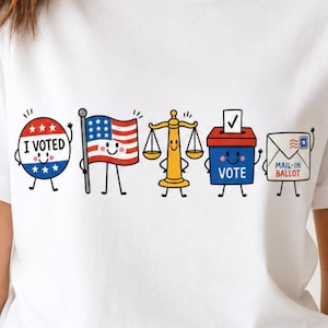 Op de afbeelding: Een wit t-shirt met een grafische print van vijf stripfiguren: een ronde 'I VOTED'-button, een Amerikaanse vlag, een gouden weegschaal van de gerechtigheid, een blauwe stembus met 'VOTE' en een witte envelop met 'MAIL-IN BALLOT'.