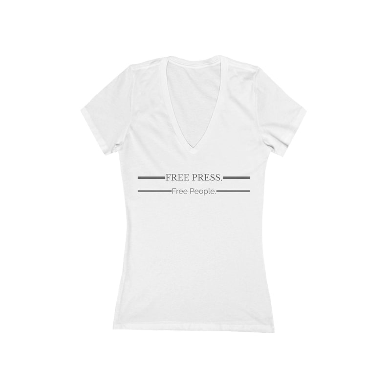 May include: White V-neck t-shirt with short sleeves. The shirt features the text "FREE PRESS." above "Free People." in gray, with a horizontal line above and below the text. The shirt is made of a soft material.