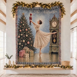 May include: A woven tapestry throw blanket featuring a ballerina in a lace dress holding a nutcracker, with a decorated Christmas tree, wrapped gifts, and a grandfather clock. The text The Nutcracker is printed at the top in a script font.