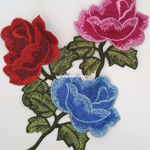 May include: Embroidered floral patches with three roses in red, pink, and blue, with green leaves and stems. The patches are on a white background. Text at the bottom reads "Free Shipping (Untracked)".