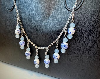Cadena para bolso de plata con dijes marcadores de puntadas inspirados en la porcelana.