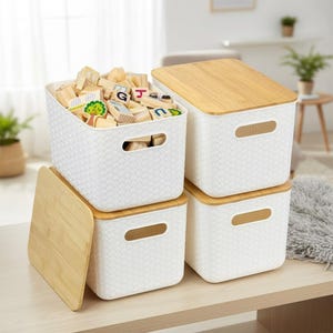 May include: Four white storage bins with woven texture and bamboo lids. One bin is filled with wooden blocks. The bins have cut-out handles. The lids are light brown. The bins are stacked on a light brown surface.