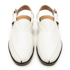 Puede incluir: Un par de sandalias de cuero blanco con un dise&ntilde;o &uacute;nico. Las sandalias tienen una correa en el tobillo con cierre de hebilla. Las suelas son negras con un borde marr&oacute;n. Las sandalias miden aproximadamente 25 cm de largo.