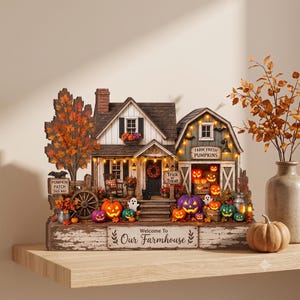 Può includere: Una scena decorativa da tavolo a tema fattoria con casa e fienile, zucche illuminate, fogliame autunnale e insegne con le scritte "Pumpkin Patch This Way", "Trick or Treat", "Farm Fresh Pumpkins" e "Welcome To Our Farmhouse".