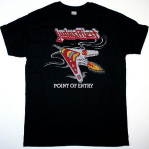 May include: A black short-sleeve t-shirt featuring a graphic of a red and white flying vehicle with flames emitting from the back. The text Judas Priest appears in red and white at the top, and the words POINT OF ENTRY are printed in white below.