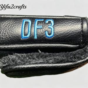 May include: Black leather golf club head cover with blue embroidered "DF3" text. The cover has a textured surface and a soft, fuzzy interior lining. The brand name "Yifu2crafts" is in the top left corner.