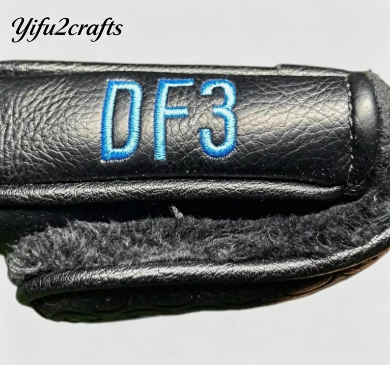 May include: Black leather golf club head cover with blue embroidered "DF3" text. The cover has a textured surface and a soft, fuzzy interior lining. The brand name "Yifu2crafts" is in the top left corner.