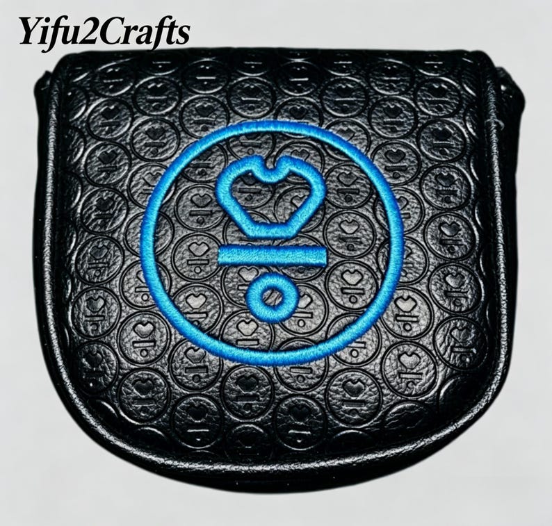 May include: Black golf club head cover with a blue embroidered design featuring a crown and circle. The cover has a textured pattern of circles and hearts. The text "Yifu2Crafts" is at the top.