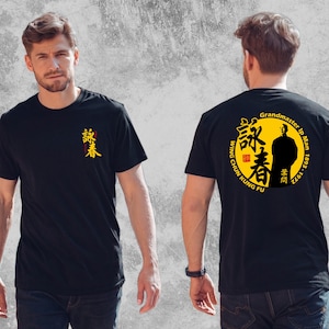May include: A black t-shirt featuring a small yellow and red Chinese character graphic on the front chest. The back displays a large yellow circle with a silhouette of Grandmaster Ip Man, Chinese characters, and the text Wing Chun Kung Fu.