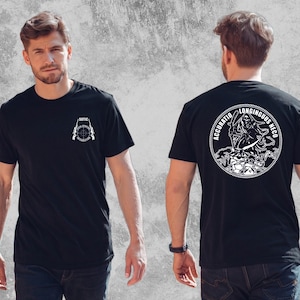Peut inclure: Un t-shirt noir à manches courtes avec un motif blanc sur la poitrine représentant une cible et le texte SOTIC SPECIAL OPERATIONS INTERDICTION. Le dos présente un grand motif circulaire blanc d'une faucheuse avec le texte ACCURATIO LONGINGUUS NECO.