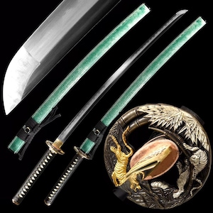 Könnte beinhalten: Drei japanische Katana-Schwerter mit grünen Griffen und silbernen Klingen werden vor schwarzem Hintergrund gezeigt. Die Griffe sind mit schwarzem Kordel umwickelt. Ein dekorativer runder Handschutz zeigt Tiger und Bambus.