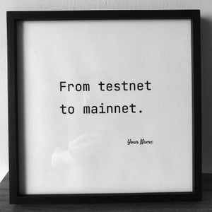 May include: Black framed print with the text "From testnet to mainnet." in a bold, sans-serif font. The phrase "Your Name" is written in a cursive font at the bottom of the print.