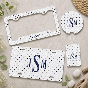 May include: A white license plate frame, a rectangular license plate, a circular car coaster, and a rectangular luggage tag, all featuring a navy blue polka dot pattern and a navy blue monogram with the letters JSM in a serif font.