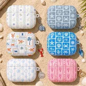 May include: Six AirPod cases with beach-themed designs, including starfish, seashells, and lobsters. The cases are in various colors, such as blue, pink, and white, and have matching charms. The cases are on a sandy surface with seashells.
