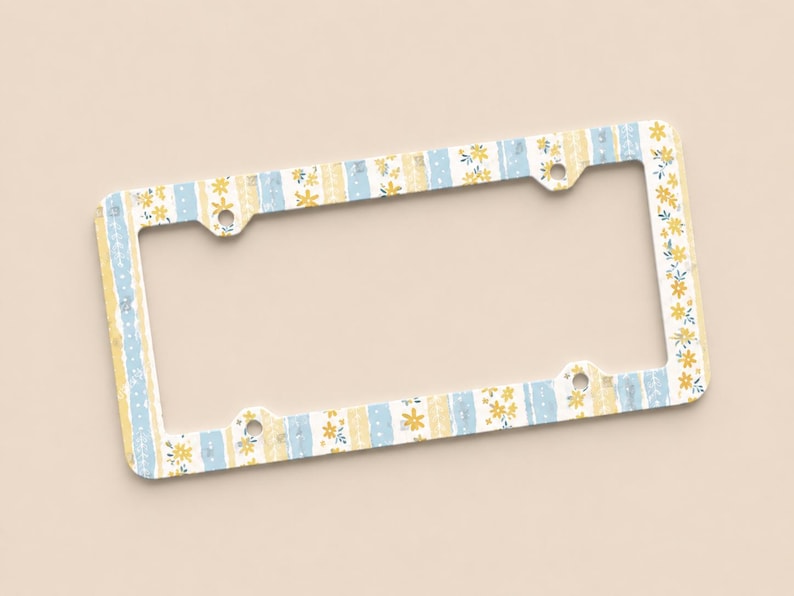 Op de afbeelding: Een decoratief kentekenplaatraam met een bloemen- en streepjespatroon in geel en blauw. Het frame heeft een witte achtergrond en is ontworpen voor een standaard kentekenplaat. Het frame heeft vier montagegaten.