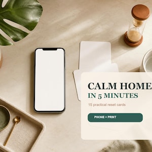 Puede incluir: Un teléfono inteligente con pantalla blanca en blanco junto a un juego de tarjetas con el texto CALM HOME IN 5 MINUTES, 15 practical reset cards y un botón con la etiqueta PHONE + PRINT. Las tarjetas se muestran junto a un reloj de arena.