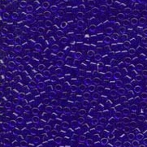 May include: Close-up of a pile of small, round, transparent, dark blue glass beads. The beads are scattered, creating a textured surface. Ideal for jewelry making and crafts.