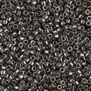 May include: A large quantity of small, silver-colored seed beads. The beads are round and have a smooth, shiny finish.