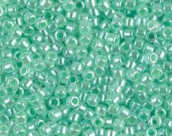 May include: A large quantity of small, round, light green glass beads with a subtle iridescent sheen.