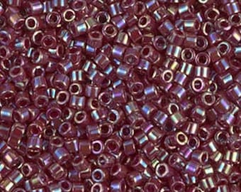May include: A close-up image of a large quantity of small, round, iridescent purple glass beads. The beads have a metallic sheen and are perfect for jewelry making.