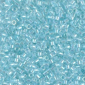 May include: A close-up view of a large quantity of small, light blue seed beads. The beads are round and have a slight iridescent sheen.