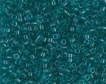May include: A close-up image of a large quantity of teal blue seed beads. The beads are small and round, and they are all the same size.